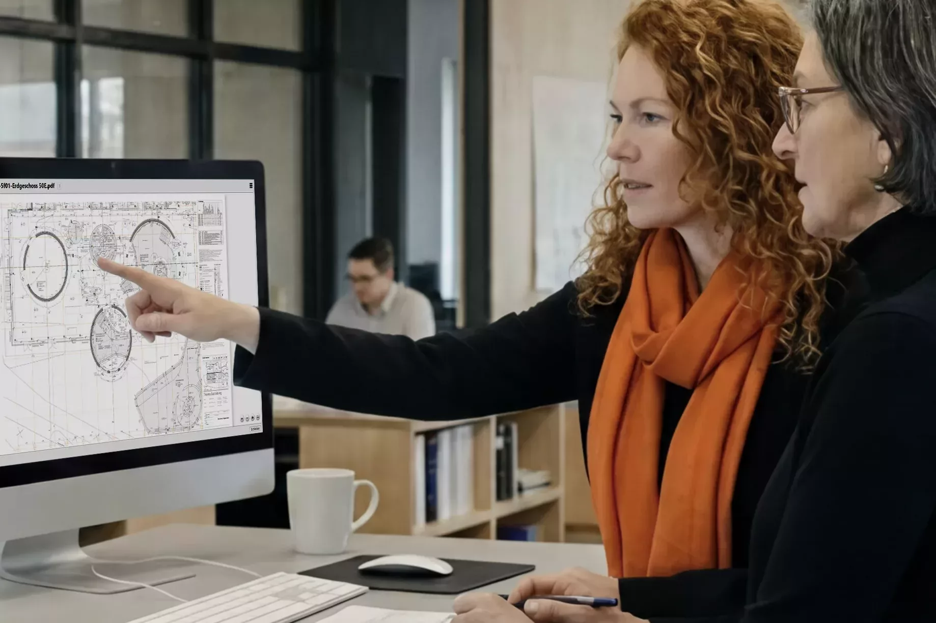 A planning team reviews digital building plans on a computer using Poolar.Project at an architectural practice